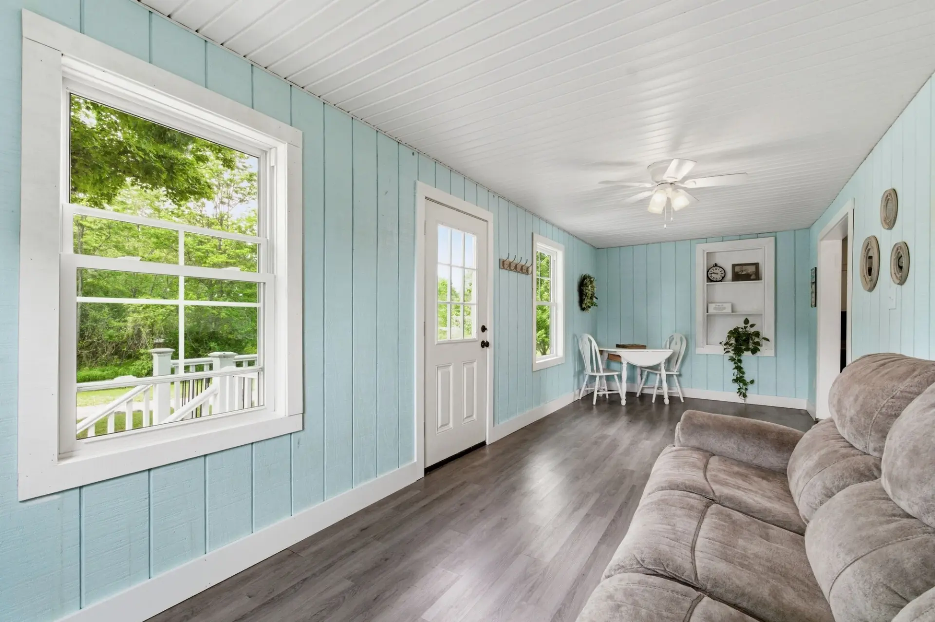 Light blue sunroom with wood floors in a Northwest PA listing
