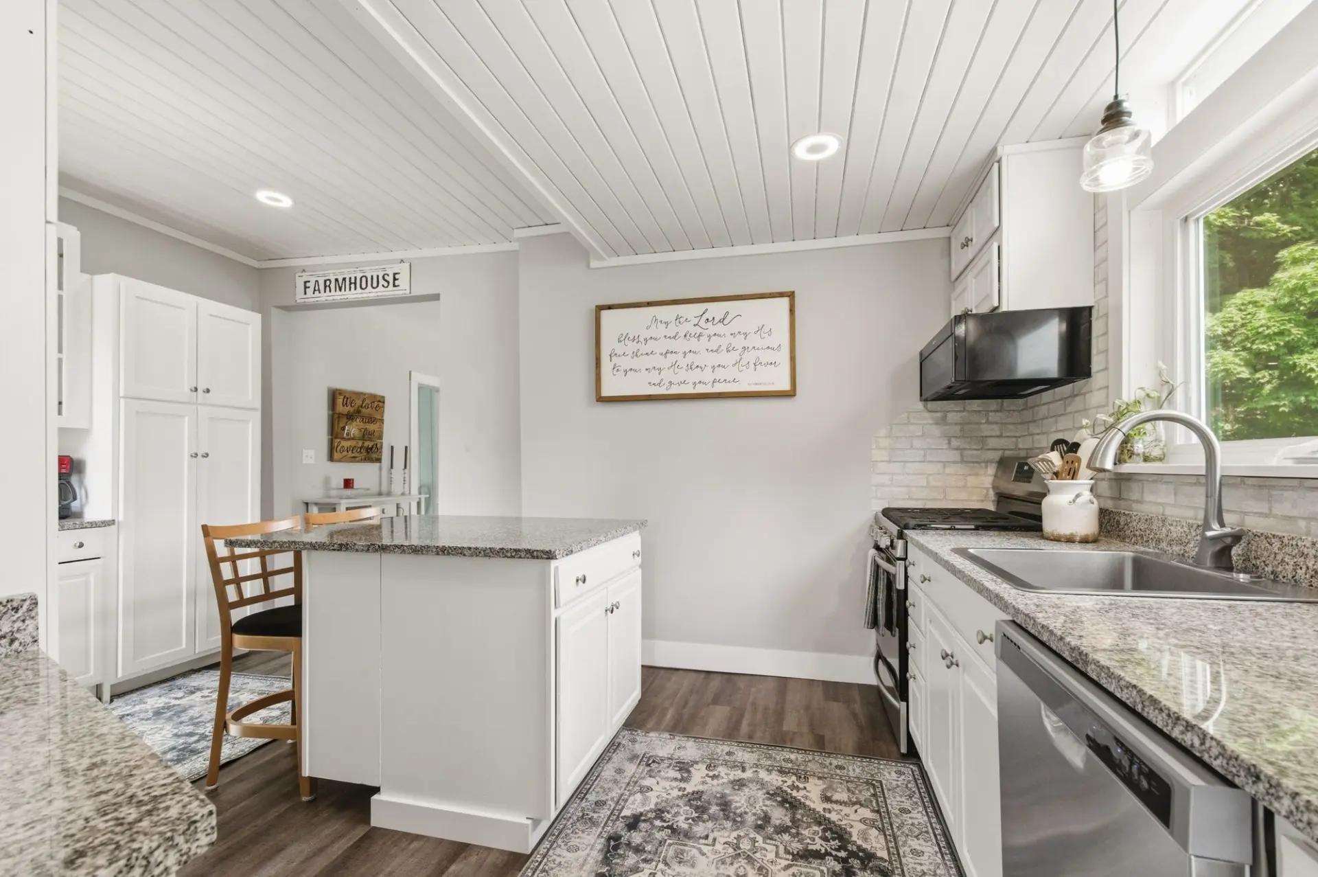Bright white farmhouse kitchen with granite island in Erie, PA